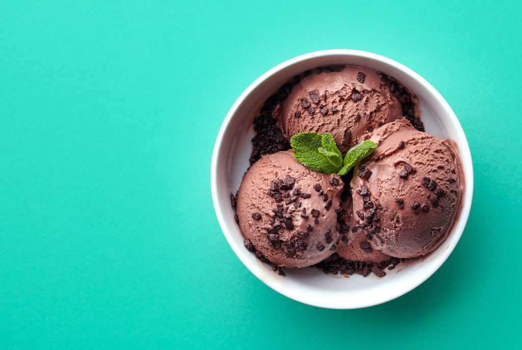 bowl of chocolate ice cream on green background